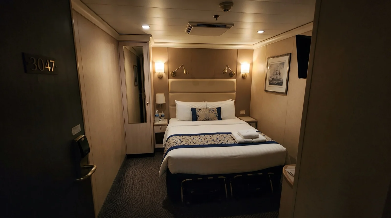 Inside cruise cabin viewed from the doorway with no window, showing the full room layout for a first-time cruiser
